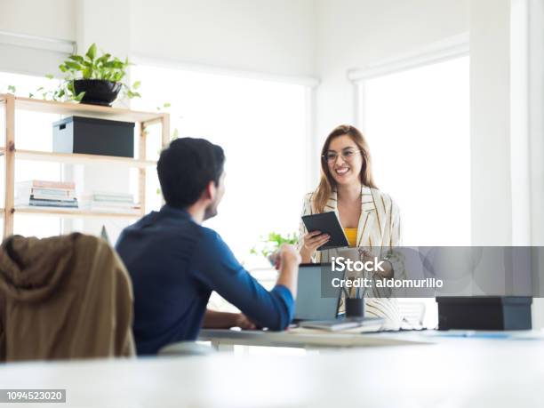 Hispanic Woman And Man Working In And Office Stock Photo - Download Image Now - 20-29 Years, Adult, Adults Only