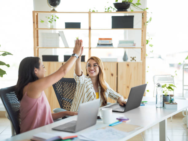 istock Two young women celebrating with high five at the office 1094523176
