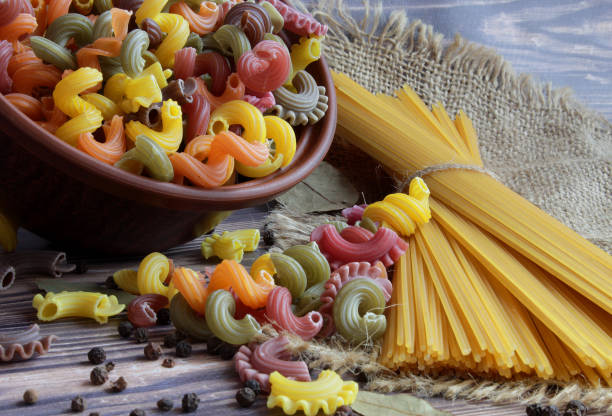 istock Pasta of different colors, spaghetti, black pepper and bay leaf lie on the table. 1094525358