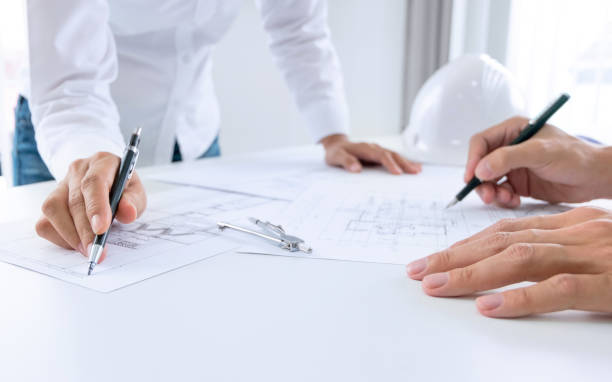 istock Close up of engineer hands discussing a building construction project at workplace 1094530468