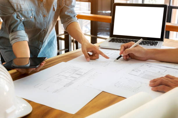 istock Close up of engineer hands discussing a building construction project with blank screen laptop at workplace 1094530614