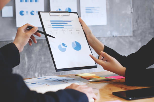 istock two business executives analyzing data paper on a clipboard  at meeting room 1094530718
