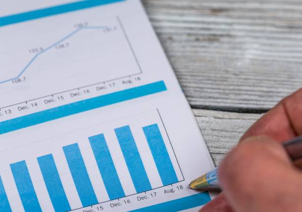 istock Close-up of male hand with pen over graph 1094536140