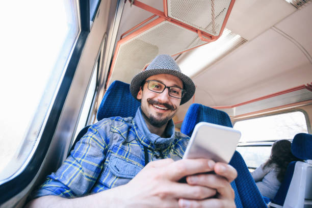 istock Smiling young man using smart phone inside of a trian 1094536358