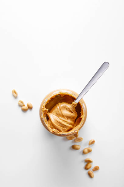 An empty peanut butter jar with spoon inside; isolated on white.