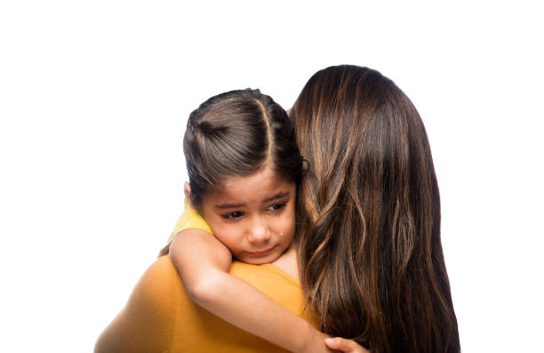 Sad Indian girl holding her mothers hand