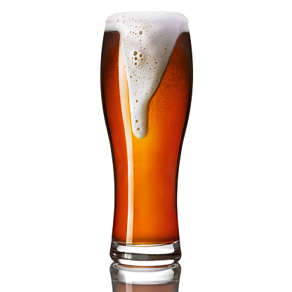 Classic draft pale ale beer in a weizen glass isolated on white background.