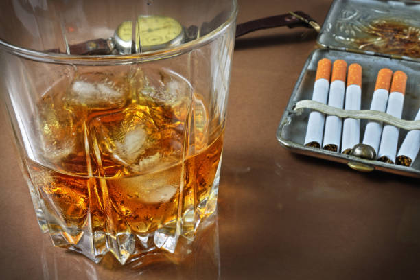 istock Whisky glass, cigarette case with cigarettes and hours 1094539522