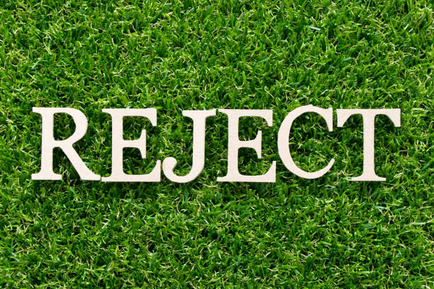 istock Wood alphabet in word reject on artificial green grass background 1094540802