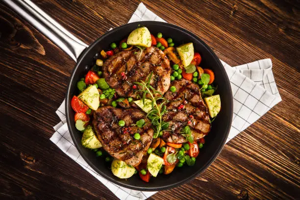 Grilled pork chop and vegetables in pan
