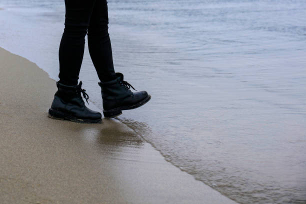 Woman with boots on the beach