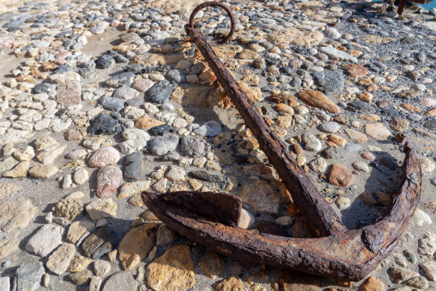 istock Old rosty anchor on the shore. 1094547110
