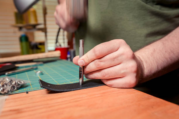 istock Punching a Hole for a Rivet Into Leather Strip 1094549064