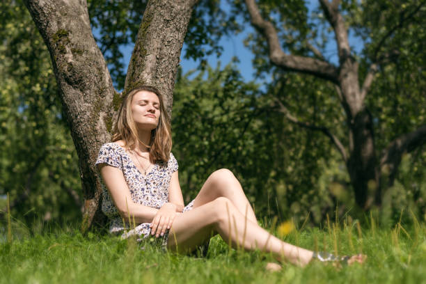 istock Attractive young woman resting under a tree in the spring garden 1094559558