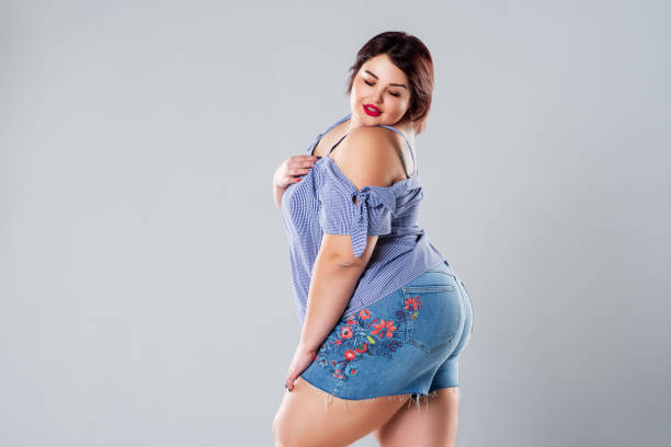 plus size fashion model in jean shorts, fat woman on gray background - sex symbol sensuality women overweight imagens e fotografias de stock