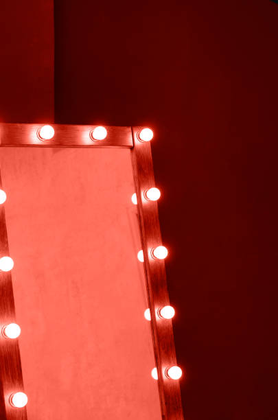 A large wooden mirror with backlit coral color. A large wooden mirror with backlit coral color. Coral color 2019. theatre mirror stock pictures, royalty-free photos & images