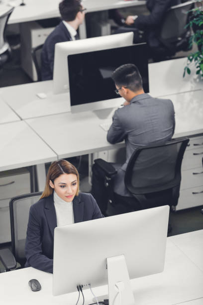 istock high angle view of male and female business people using desktop computers in open space office 1094561298