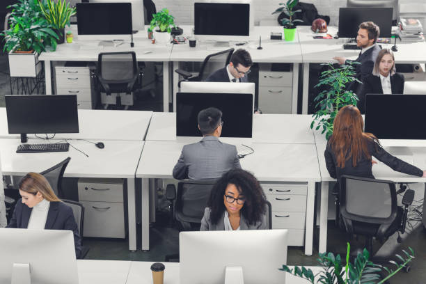 istock high angle view of professional multiethnic business people working with desktop computers in open space office 1094561304