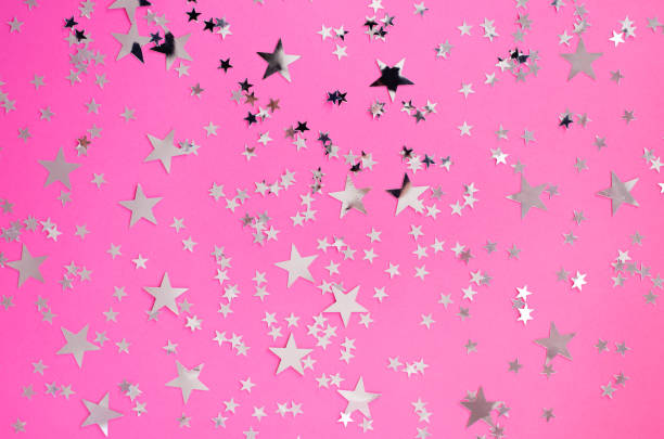 istock Silvery stars of different sizes on a pink background. 1094561930