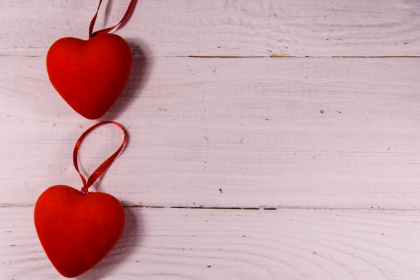 istock Two red hearts on a white wooden table. Top view 1094570314
