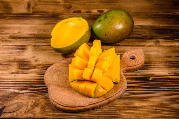 istock Cutting board with chopped mango fruit on a wooden table 1094570378