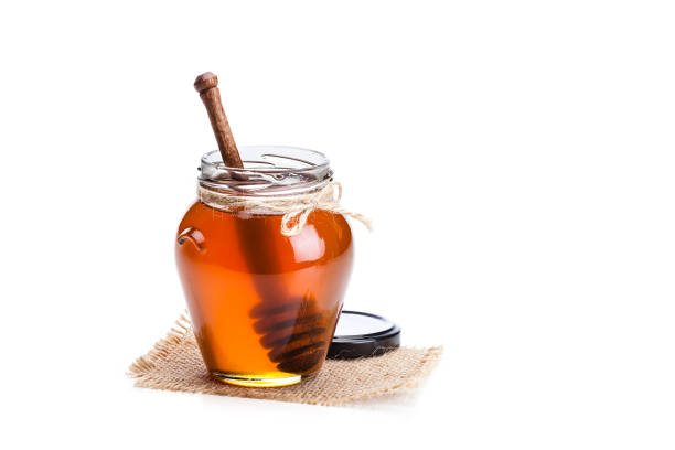 honig-glas mit honig dipper isoliert auf weißem hintergrund - syrup jar sticky isolated objects stock-fotos und bilder