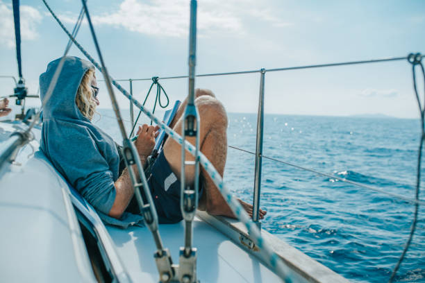 istock Man solving crossword puzzle on sailing boat 1094598222