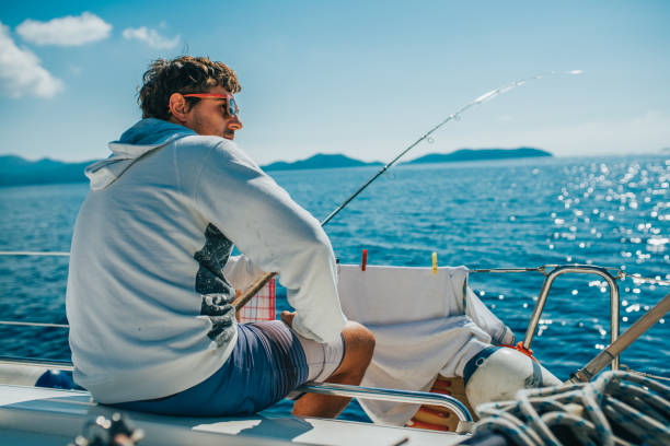 o homem sentado e barco de pesca - travel locations sea mediterranean sea wind - fotografias e filmes do acervo