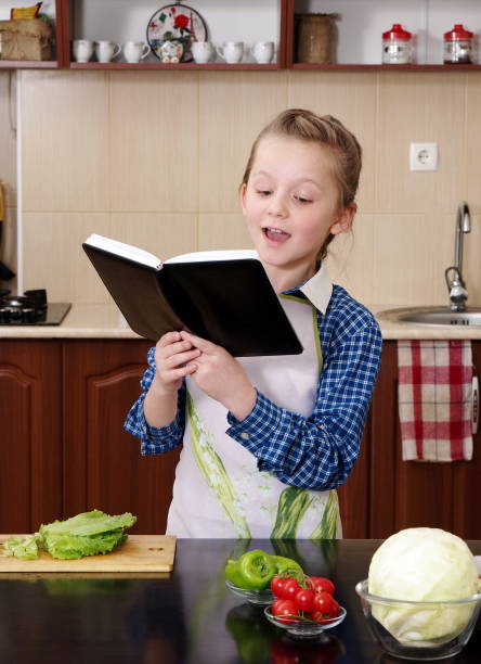 istock Cute Girl Reading Recipe Book In Kitchen 1094601298