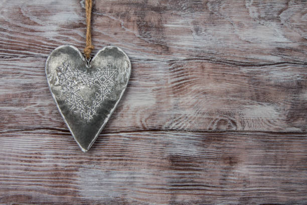 istock Silver heart suspended on rope. Wooden background 1094602886