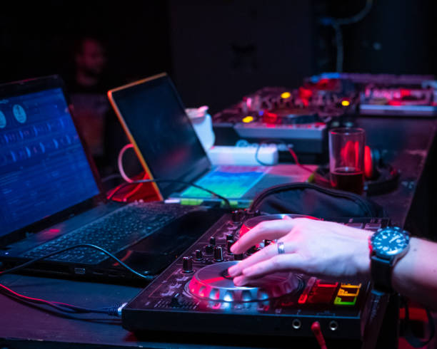 istock DJ music console and laptops in bright colors of light 1094605560