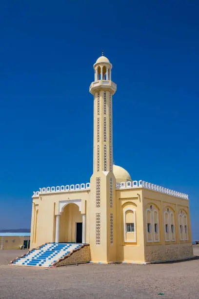 Stock photograph of a yellow colored mosque located close to the salt flats in the Gulf of Tadjoura, Djibouti on a sunny, clear day.