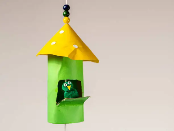Photo of Handicraft of a colorful bird house and a small bird made of toilet paper roll