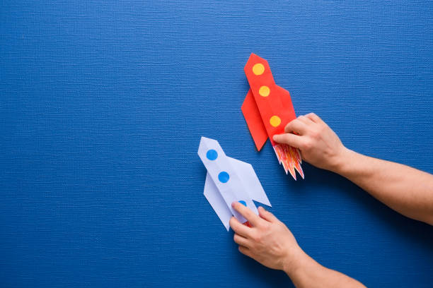 istock male hands hold a rocket from paper on a blue background 1094615222