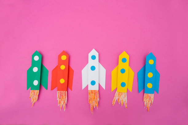 istock top view of flying multi-colored rockets from paper on a pink background 1094615522
