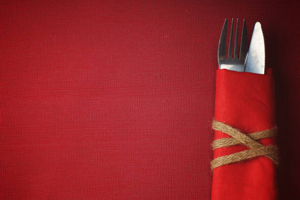 Cutlery in a napkin on a red background.