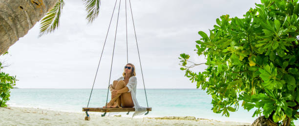 istock Woman sitting on swing on beach,Maldives 1094616022