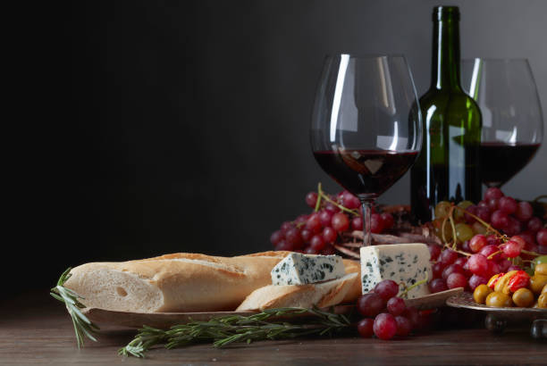 Sandwich with blue cheese and rosemary on a dark background. Delicious snack and red wine. Copy space for your text.