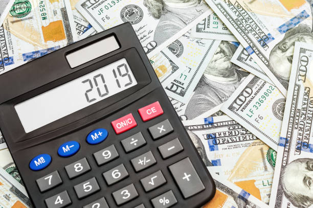 istock Calculator with numbers 2019 on background of dollar bills. 1094618084