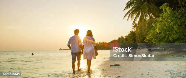 View Of Pair Walking In Watermaldives Stock Photo - Download Image Now - Beach, Maldives, Vacations