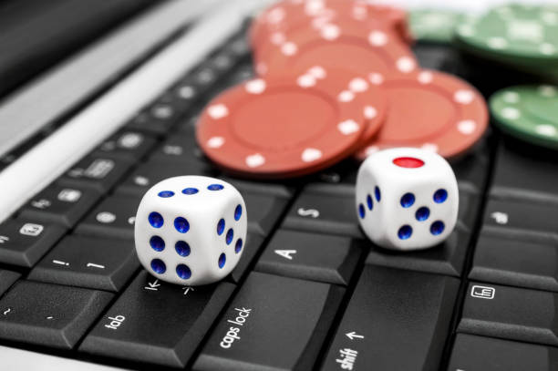istock Dice with poker chips on the laptop keyboard. 1094618270