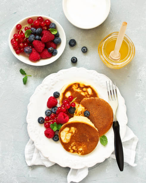 istock Breakfast - Cottage cheese pancakes,  curd fritters with raspberry, strawberry, blueberry.  Selective focu 1094618688
