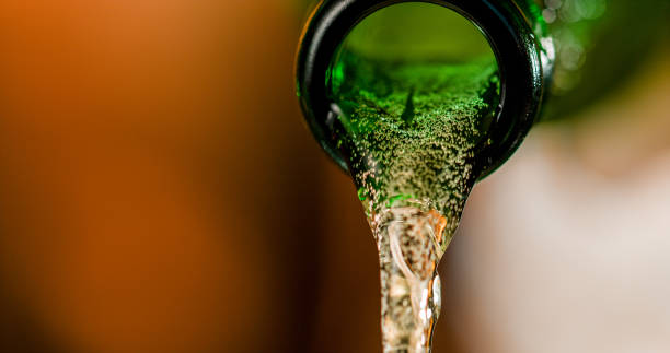 bier aus der flasche gießen - green beer fotos stock-fotos und bilder