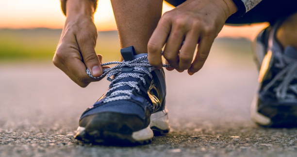 istock Man tying sport shoes while jogging 1094623424