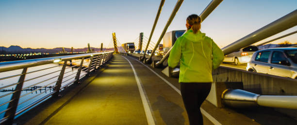 Woman jogging along bridge