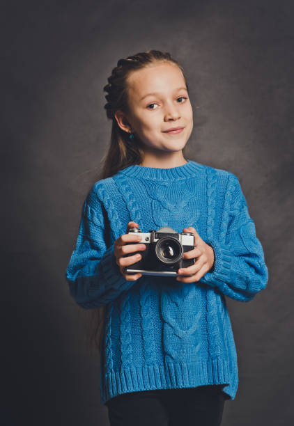 little beautiful girl with an old camera. young photographer - photographer enjoyment elegance old fashioned imagens e fotografias de stock