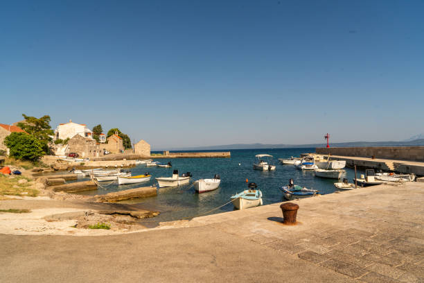 Boats moored in marina in coastal town under clear sky,Peljesac