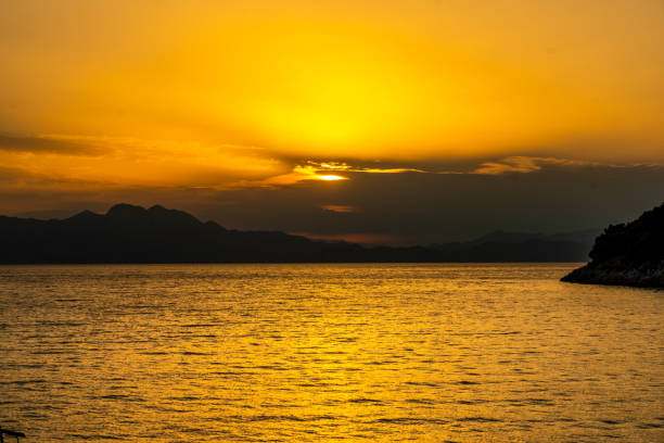 Scenic view of sun during sunset hidden by overcast sky over calm sea,Peljesac