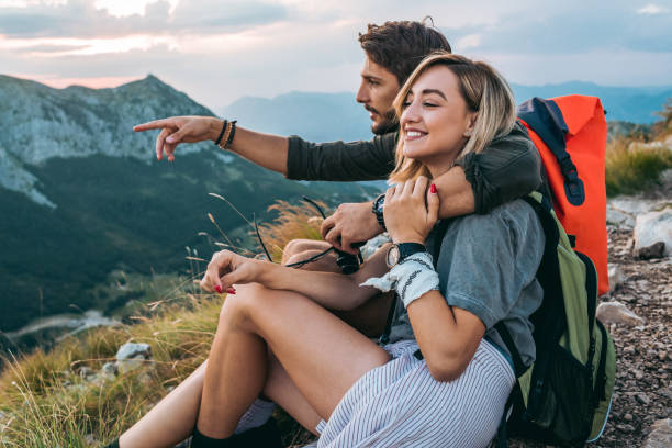 istock beautiful young couple relaxing after hiking and taking a break 1094626478