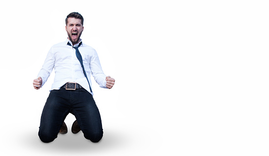 Attractive business man is celebrating on his knees isolated on a white backgrpund